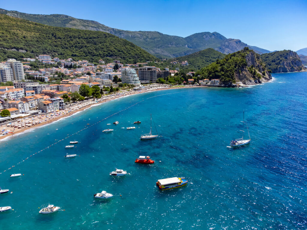 Boats bobbing in the sparkling waters off the busy beach in Petrovac Bay.