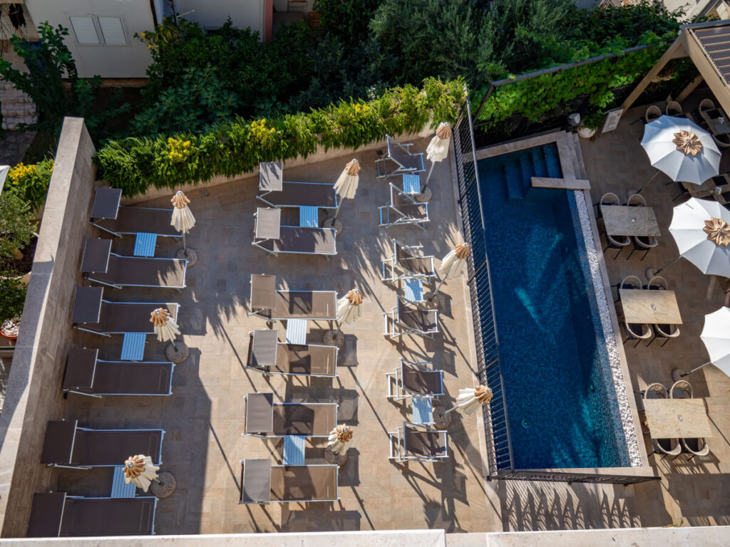 Sun loungers by a pool in Pima Hotel Budva.