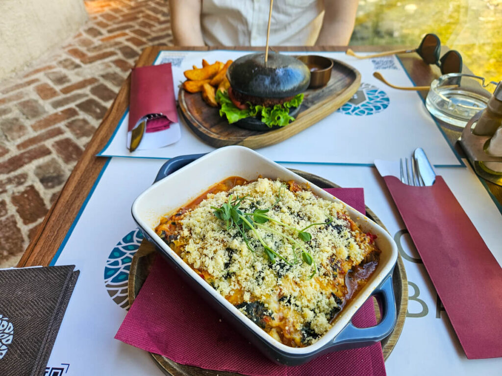 A vegetarian lasagne and vegan burger on a table in a restaurant in Kotor.
