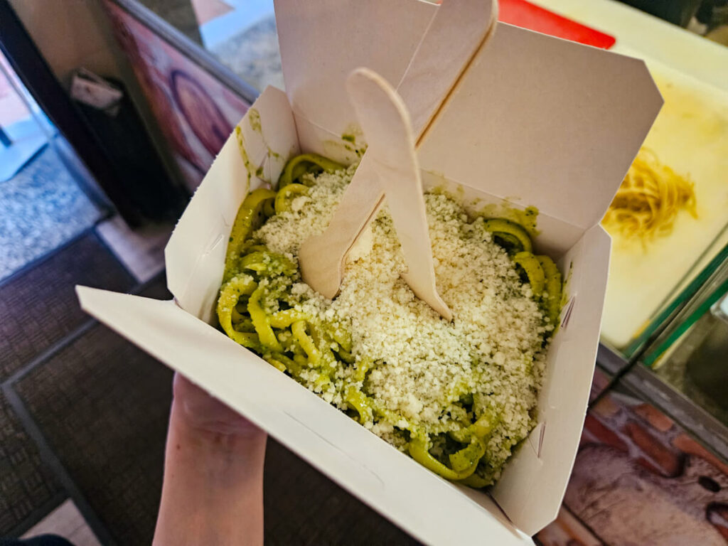 A takeaway box of cheesey pesto pasta from the Spaghetti and Wine Bar in Kotor.