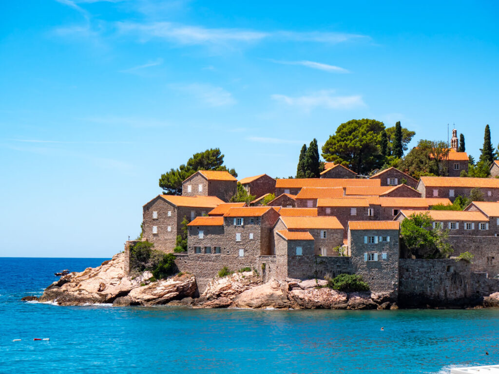 Stone houses with red roofs on Sveti Stefan Island.