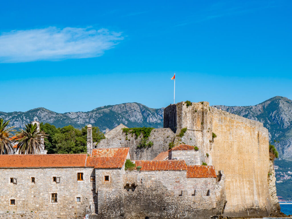 The stone walls of Budva Old Town leading to terracotta rooftops.