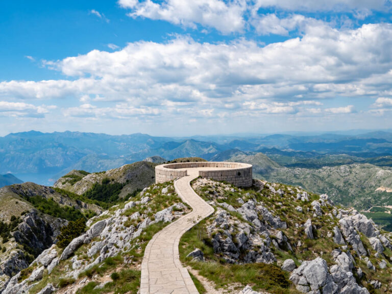 A narrow paved path leading to the circular viewpoint in Lovćen National Park.