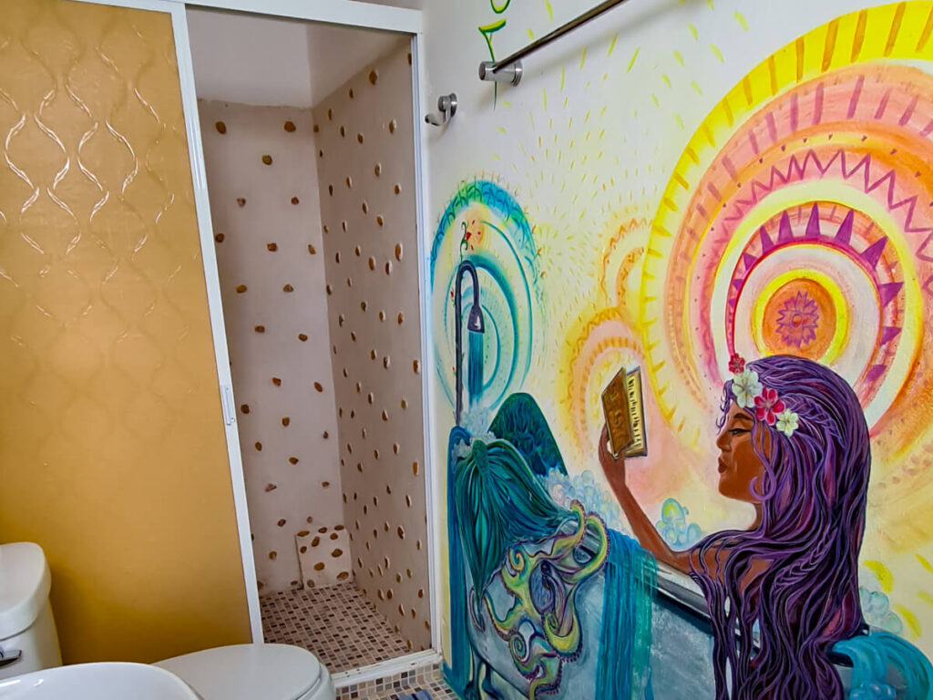 A colourful mural of a girl on a bathroom wall in a hotel room in Cozumel.